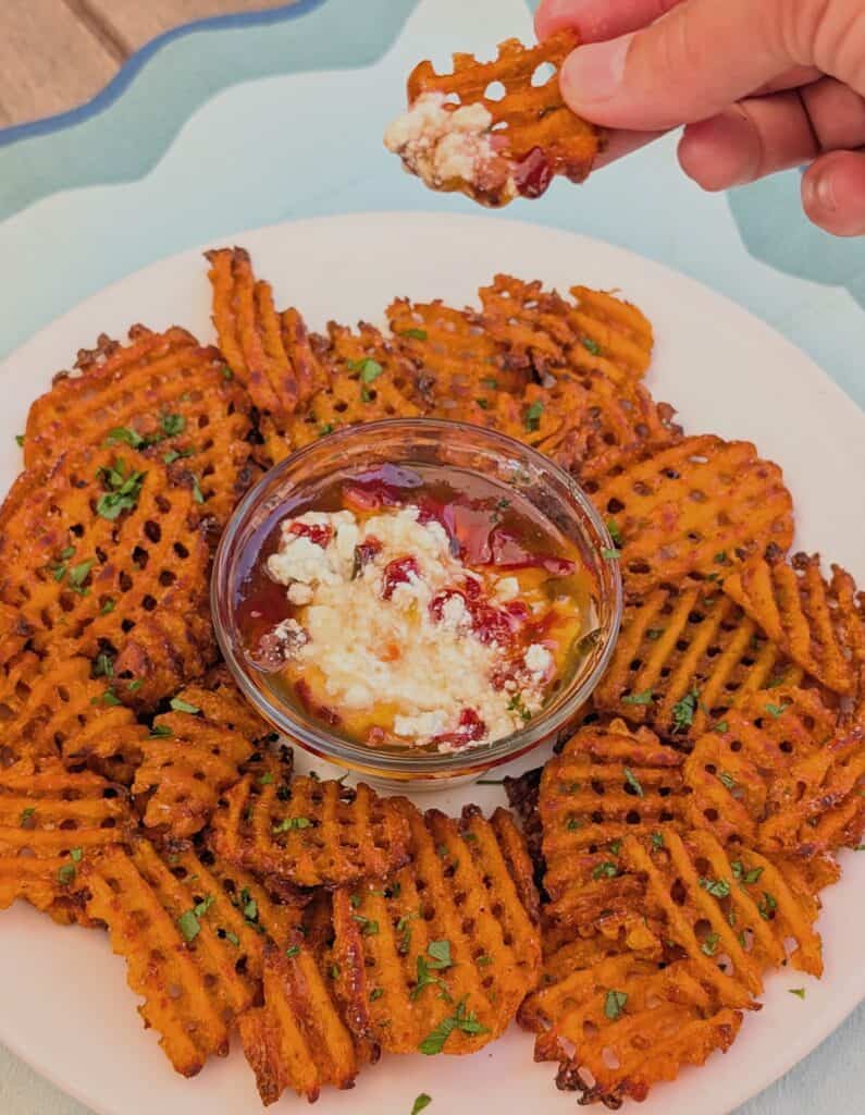 Sweet Potato Waffle Fries dipping in pepper jelly and cream cheese
