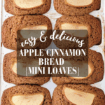 Mini applesauce bread loaves, fresh from the oven, with a slice of apple and a dusting of cinnamon on top.