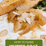 Final Plating: The appetizer bowl rests on a wooden serving board next to a sprig of fresh green oregano. Slices of buttery toasted baguette are propped up behind the dish.