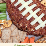 Appetizer platter featuring a football cheese ball, crackers, and raw vegetables.