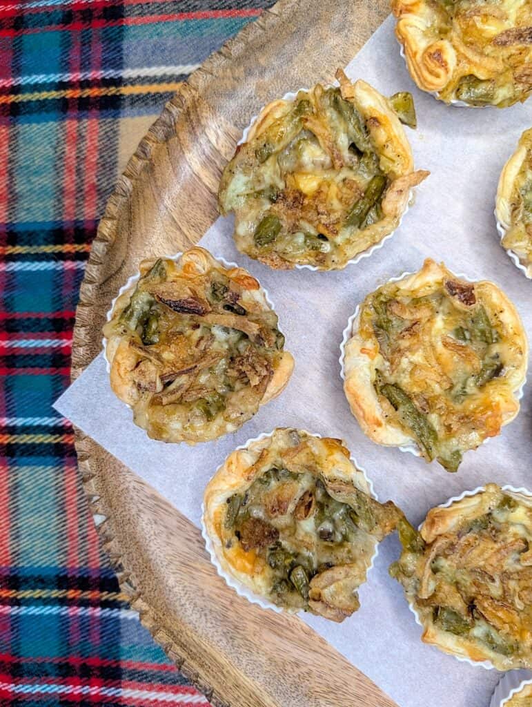 Mini Green Bean Casserole Cups Recipe {So Easy} on a round board with a plaid background
