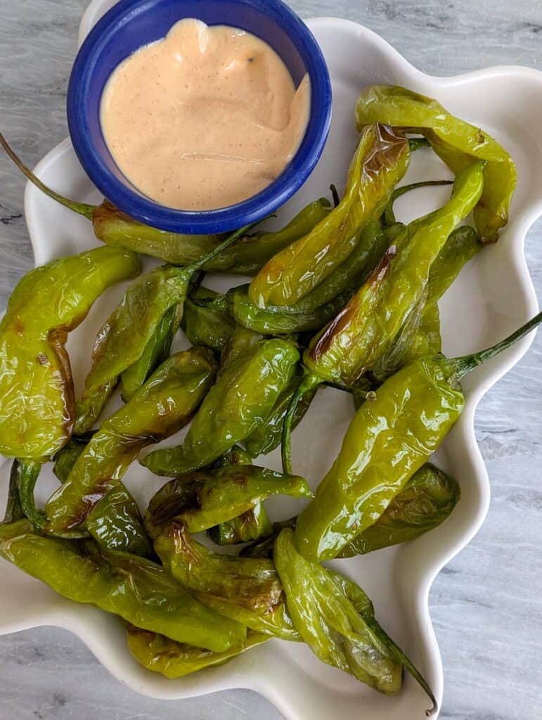 Roasted shishito peppers with dipping sauce on white platter, food and friends, appetizer, snack, healthy vegetable dish, food blog photo