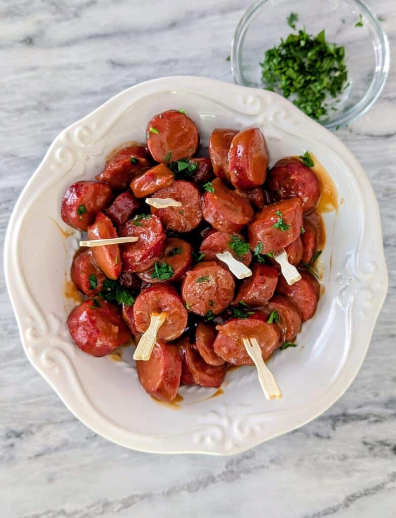 overhead shot of BBQ Smoked Sausage Bites in a white bowl with parsley