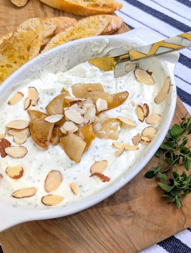 Creamy Whipped Goat Cheese Dip with Honey and Herbs with a knife for spreading 