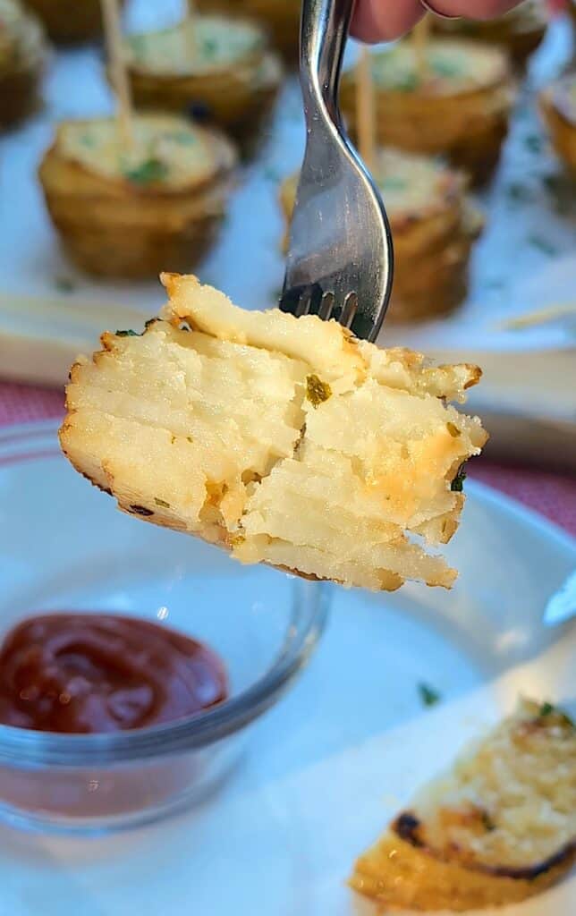 a fork holding the the crispy potato stack showing the inside layers