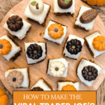 An overhead shot of square pumpkin spice cake bites on a round wooden board, decorated with assorted fall-themed chocolate candies. Text overlay reads: "How to make the viral Trader Joe's Sheet Cake Hack, The Easy Way."