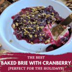 Baked brie with cranberry sauce and pistachios in a white dish, surrounded by plain and seed crackers, with a serving knife. Text overlay: THE BEST BAKED BRIE WITH CRANBERRY {PERFECT FOR THE HOLIDAYS}.