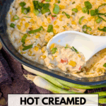 A hot creamed corn dip in a blue dish, with a white spoon scooping a portion. The dip is garnished with green onions and surrounded by purple tortilla chips. Text overlay reads: "Hot Creamed Corn Dip Recipe with Cream Cheese."