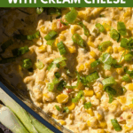 Overhead, sunlit photo of a cheesy corn dip in a blue dish, topped with green onions. Scallions and purple tortilla chips are visible in the foreground. Text overlay reads: "cozy & delicious Warm Corn Dip with Cream Cheese."