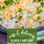 Extreme close-up of a warm, cheesy corn dip with cream cheese, garnished with fresh green onions. The dark background shows blurred purple tortilla chips. Text overlay reads: "easy & delicious Warm Corn Dip with Cream Cheese."