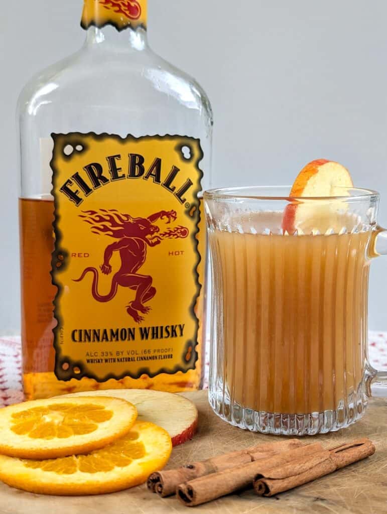 Big Batch Spiked Fireball Apple Cider recipe with fireball bottle in image