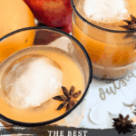 Two glasses of chilled apple cider cocktails, each featuring a large round ice sphere and a star anise garnish. The background includes fresh apples and an orange. Text overlay reads: "The Best Spiked Apple Cider Recipe {with fireball whisky}."