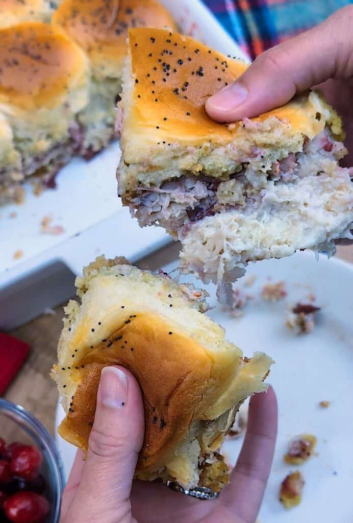 Hands holding two Turkey Cranberry Sliders pulling them apart