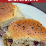 Close-up profile view of two separated turkey cranberry sliders on a white plate, showcasing the thick layer of turkey, stuffing, and cranberry filling between the golden sweet rolls. The text on the image reads "cozy & delicious TURKEY CRANBERRY SLIDERS RECIPE."