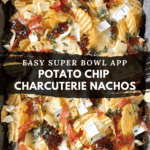 Potato chip charcuterie nachos topped with brie cheese, prosciutto, fig jam, and fresh herbs on a baking tray.