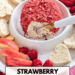 Strawberry cheese ball coated in freeze-dried strawberries with a slice removed, served with heart-shaped bread, raspberries, and apple slices.