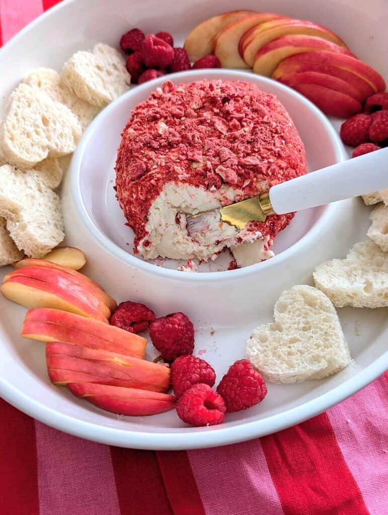 finished Strawberry Cream Cheese Dessert Cheese Ball with knife in the cheese ball 