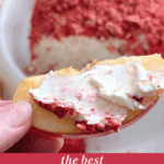 Close-up of apple slice topped with strawberry cream cheese from a sweet dessert cheese ball.