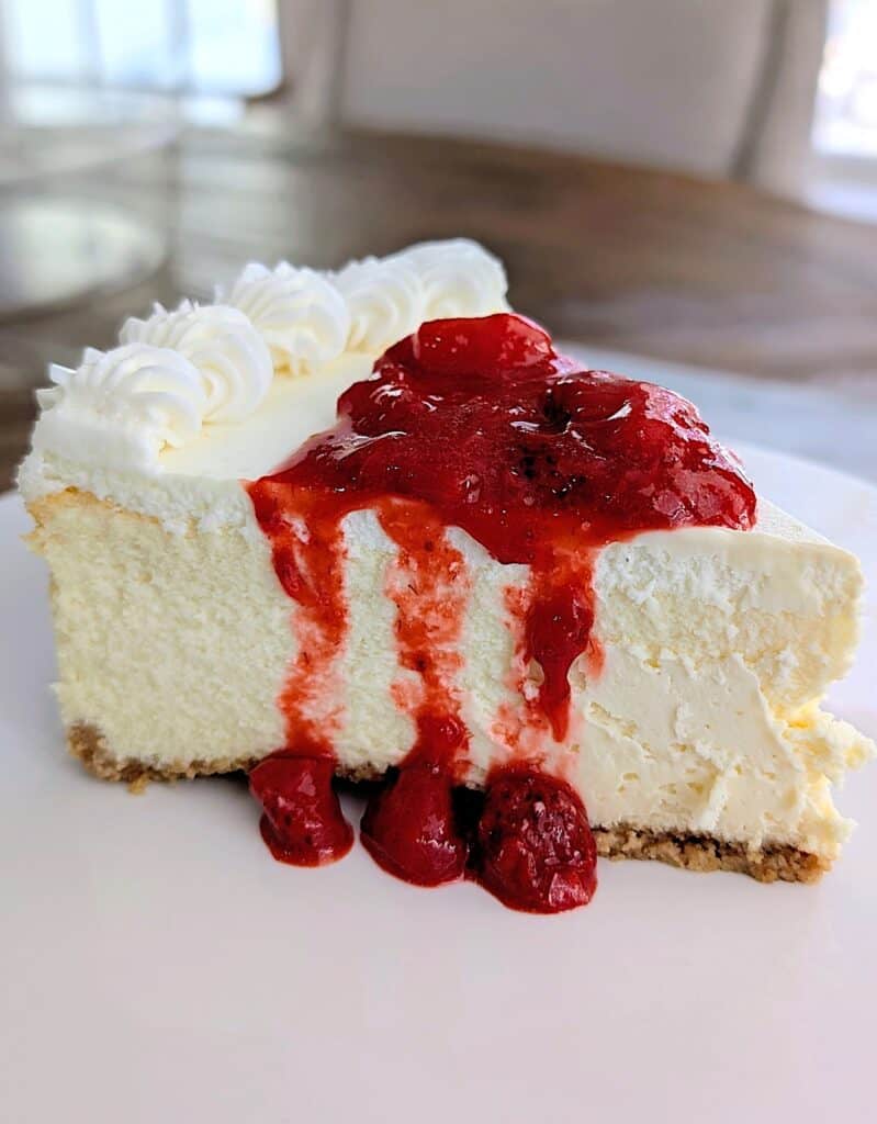 finished shot of a slice of cheesecake topped with the strawberry sauce