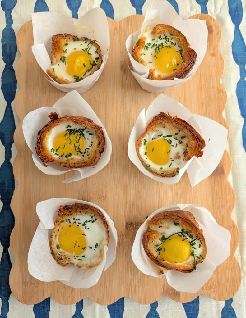 overhead shot of 6 Breakfast Croissant Egg Cups on wood platter